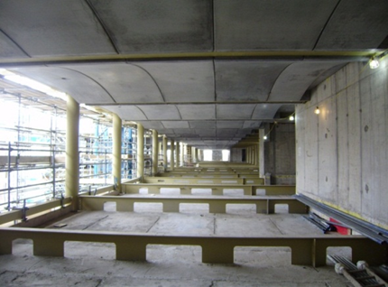 Precast concrete slabs supported by deep steel beams in which services are placed on the floor slab (Woolwhich Town Hall)