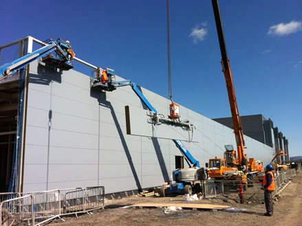 Installation of heavy cladding panels (Image courtesy of Duggan Steel)