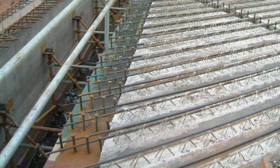 Longitudinal reinforcing bars in a skew ladder deck bridge